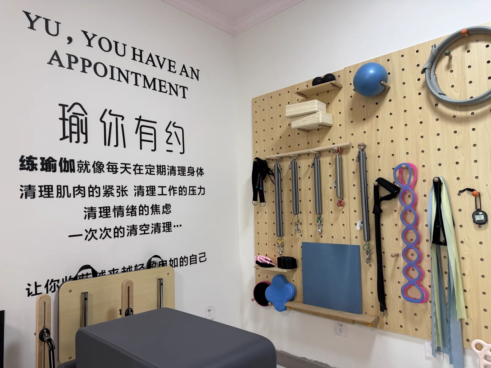 整齐收纳的瑜伽普拉提训练辅具墙